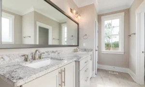 newly renovated bathroom with wide mirror and sink countertop